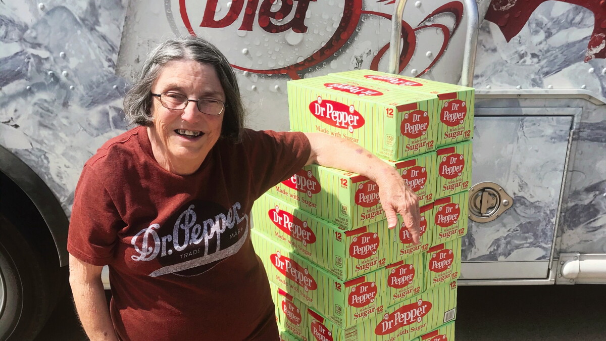 One of two winners of a year supply of Dr. Pepper receives her prize